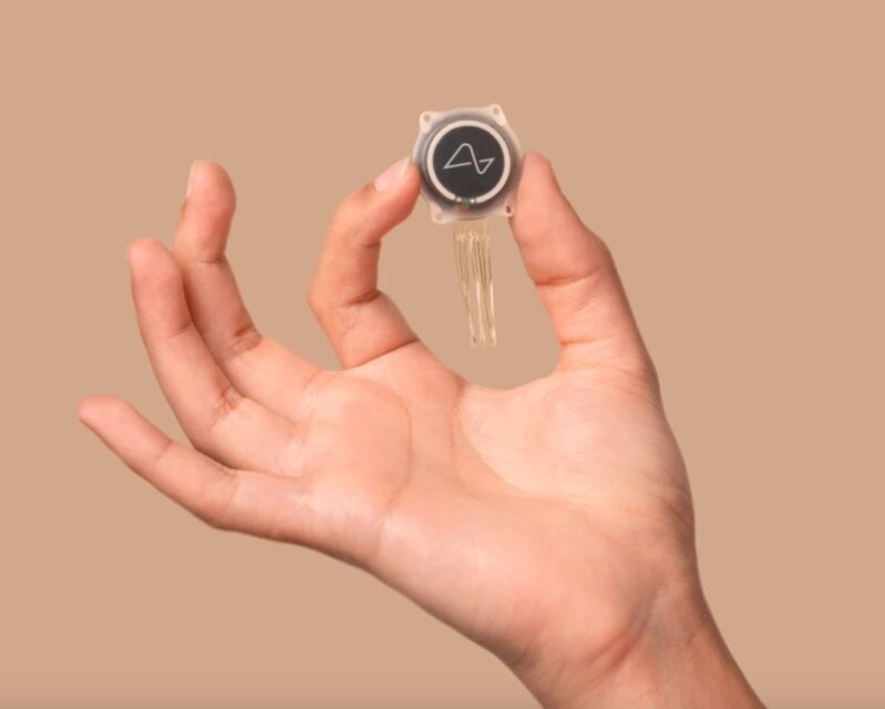 Hand holding the Neuralink brain implant