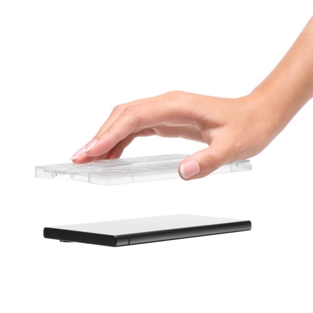 Hand holding Dbrand Prism 2.0 screen protector hovering over phone