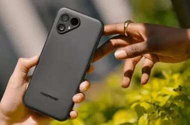 Hand holding a Fairphone while another reaches for it