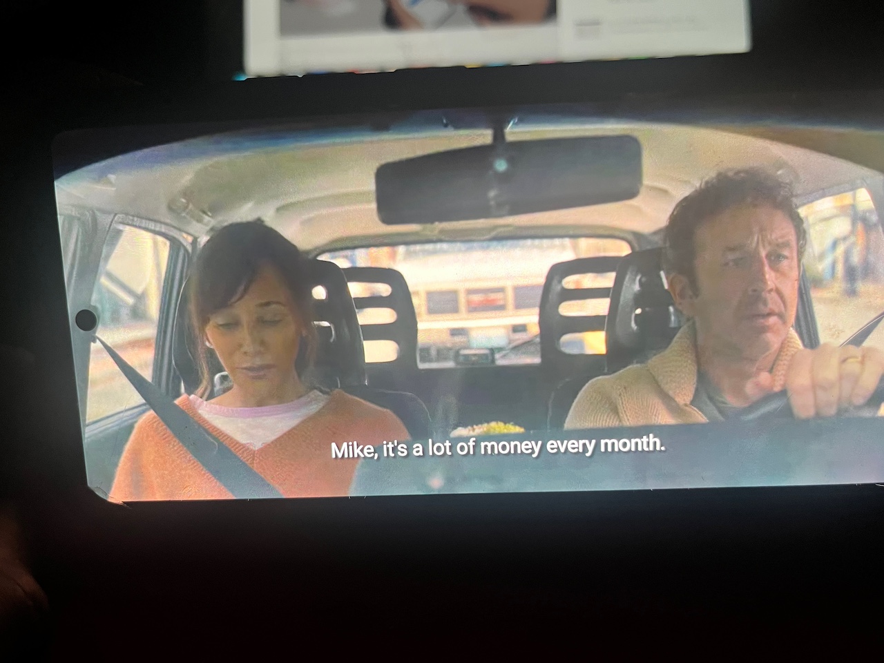 Man and woman in car discussing money in movie scene