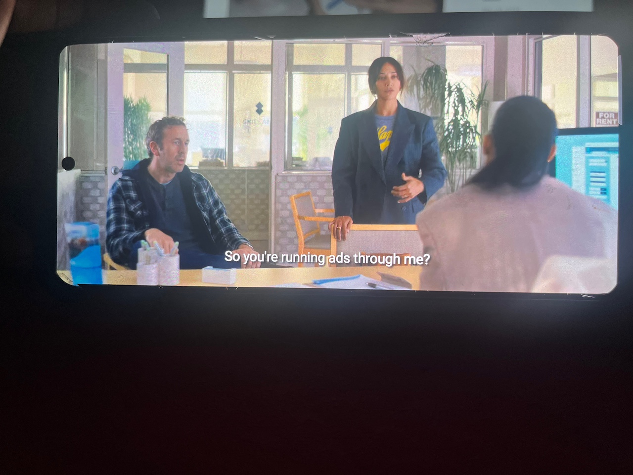 Woman asking question with two other people present in movie scene