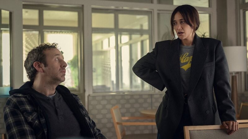 Standing woman locking eyes with sitting man