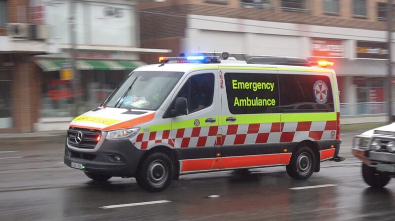 Australian ambulance moving fast on the road