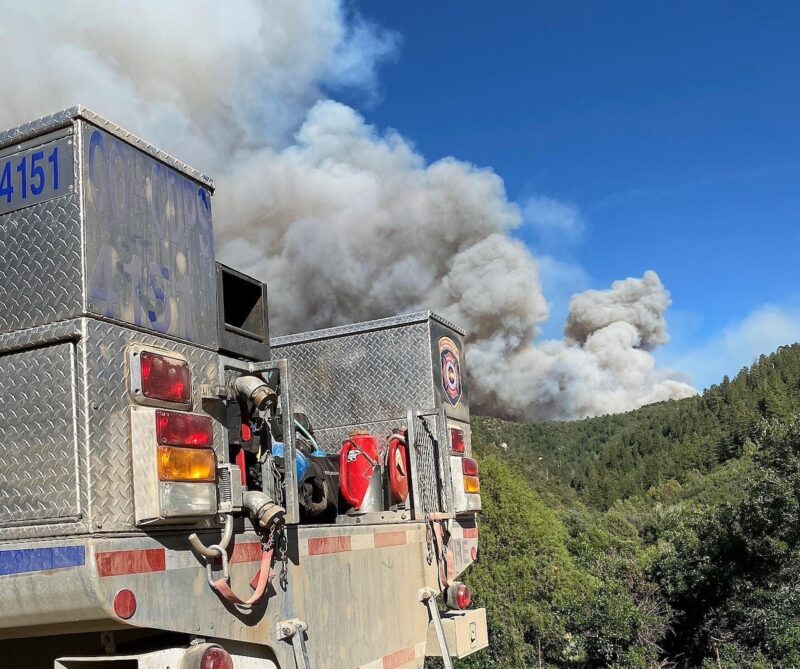 Fire truck parked near canyon on fire