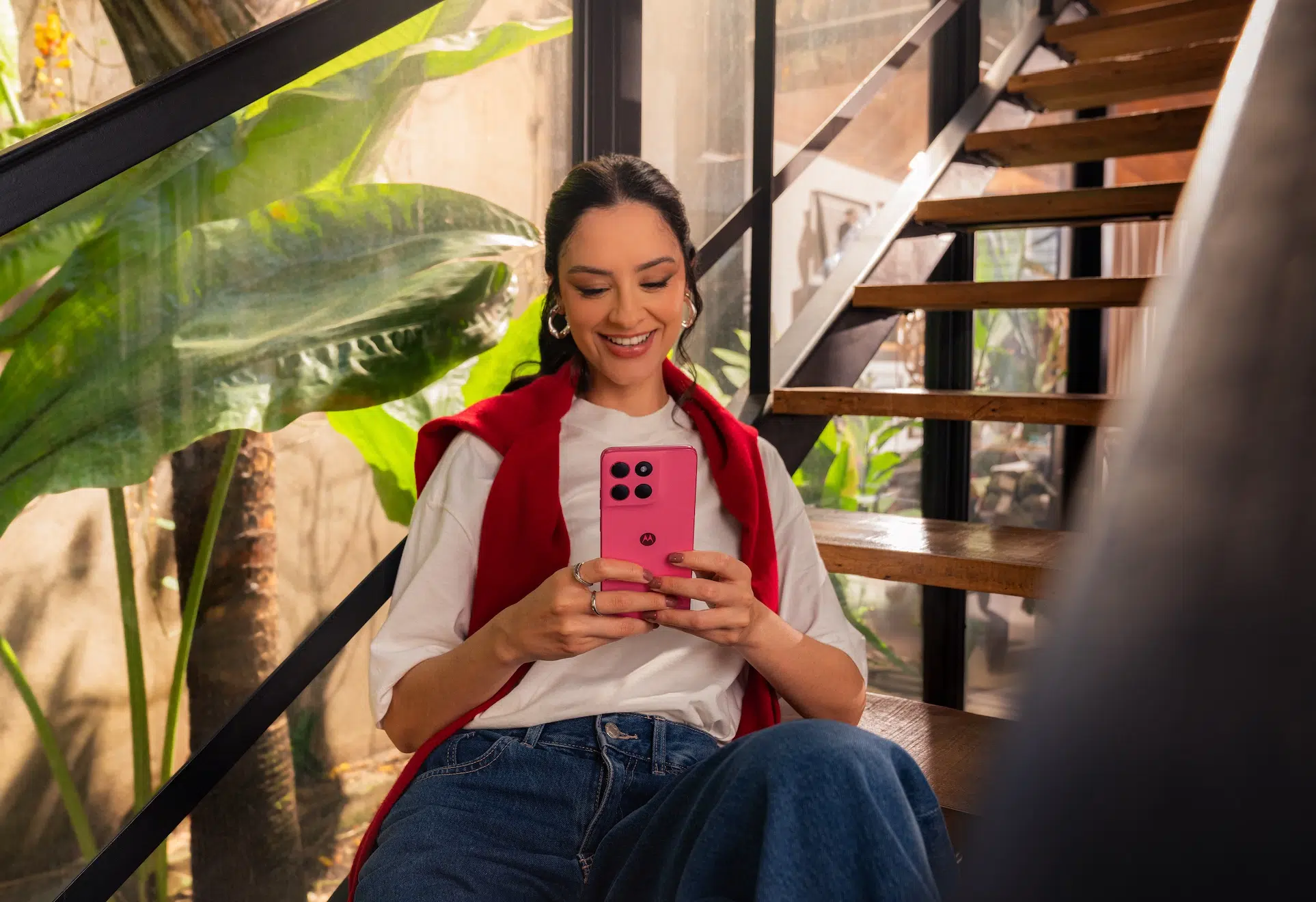 Smiling woman using pink Moto G57