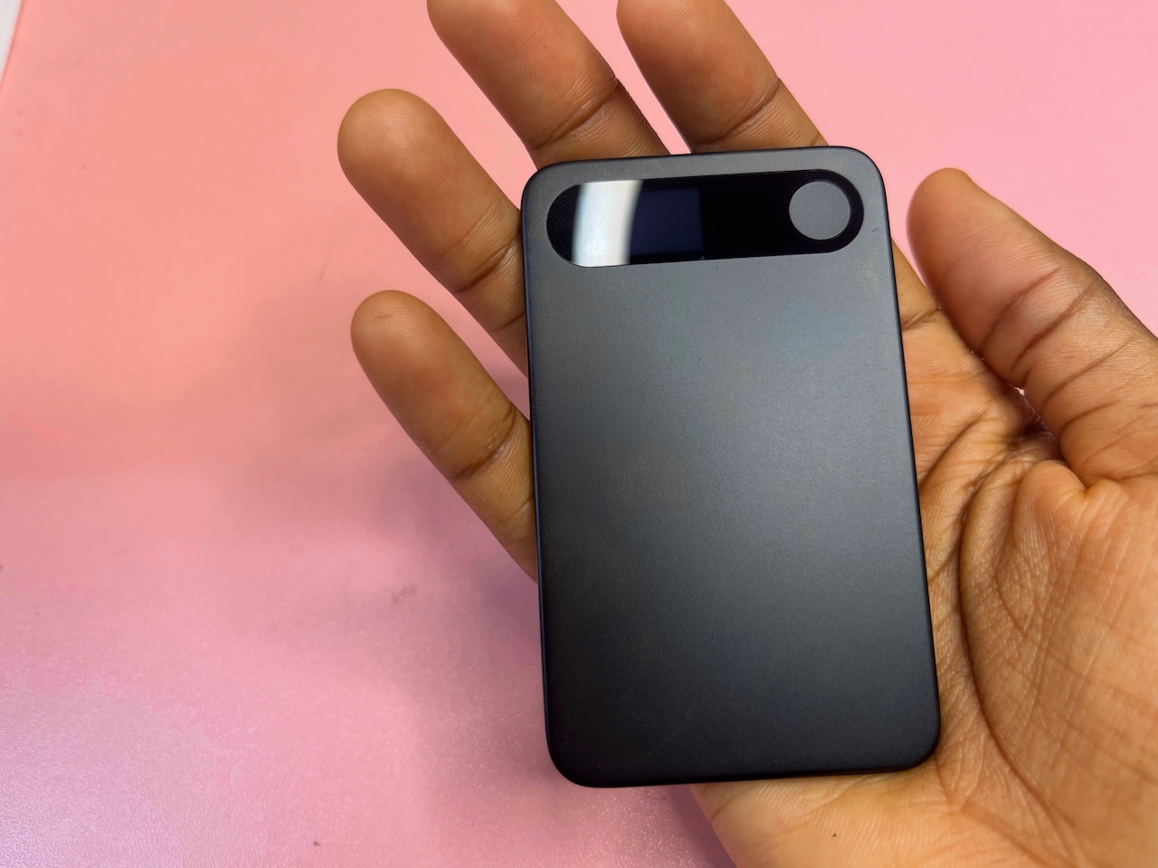 Hand holding Comulytic Note Pro with front side facing up