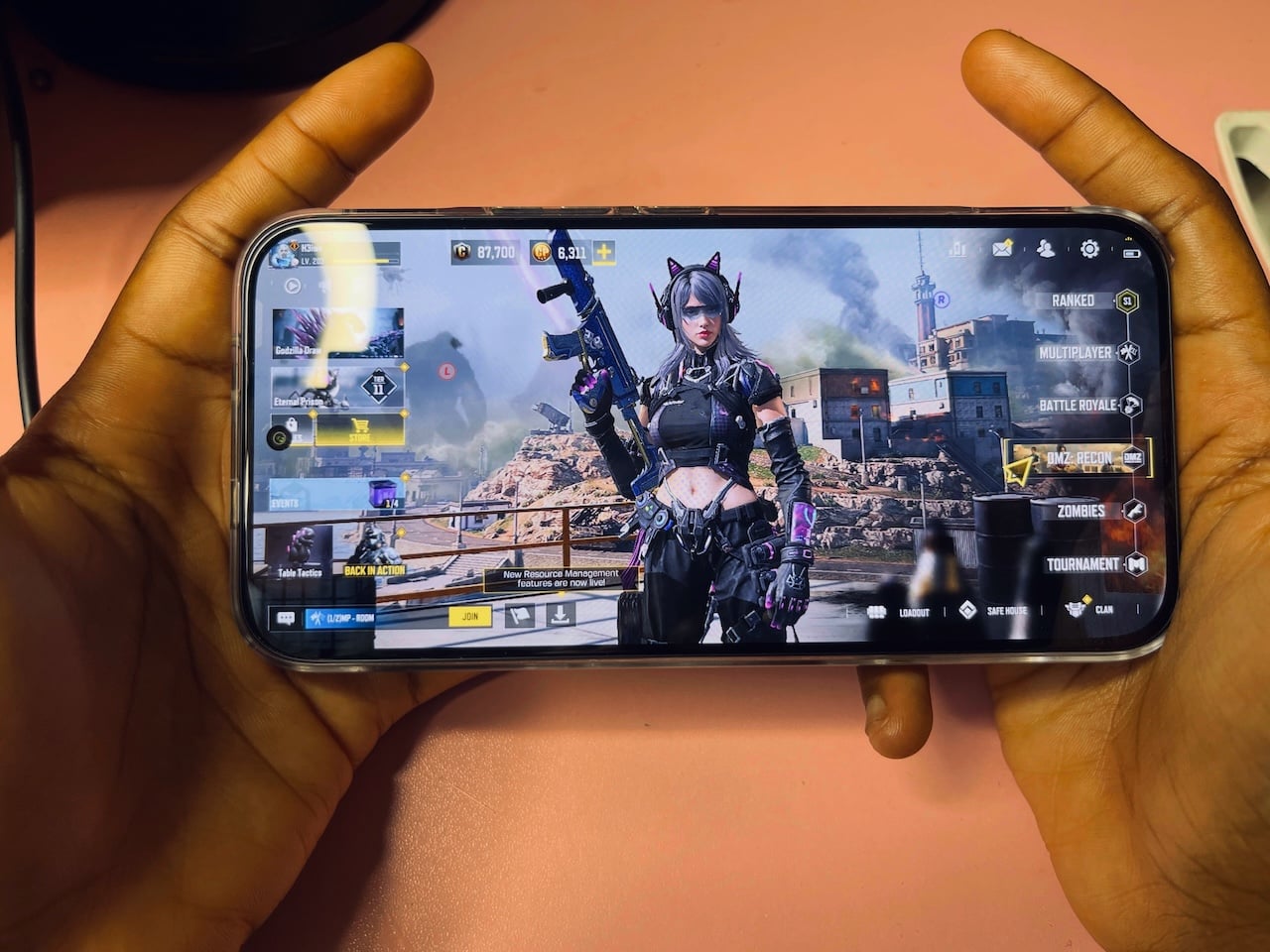 Hands holding phone with COD Mobile on the screen