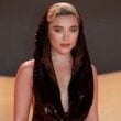 Florence Pugh wearing a black sequined hooded dress at a red carpet event.
