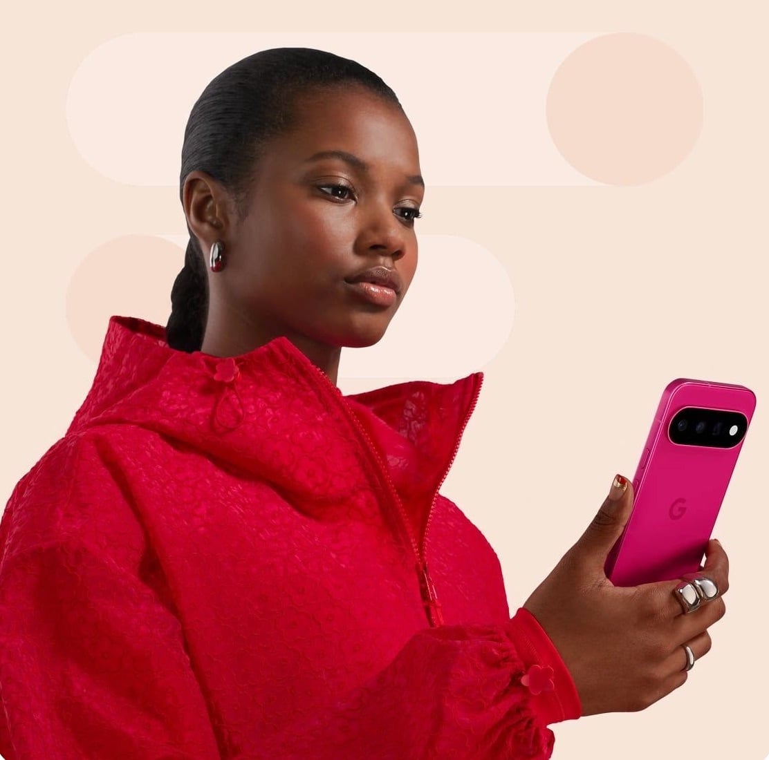 Woman in read sweater staring at pink Pixel phone in her hand