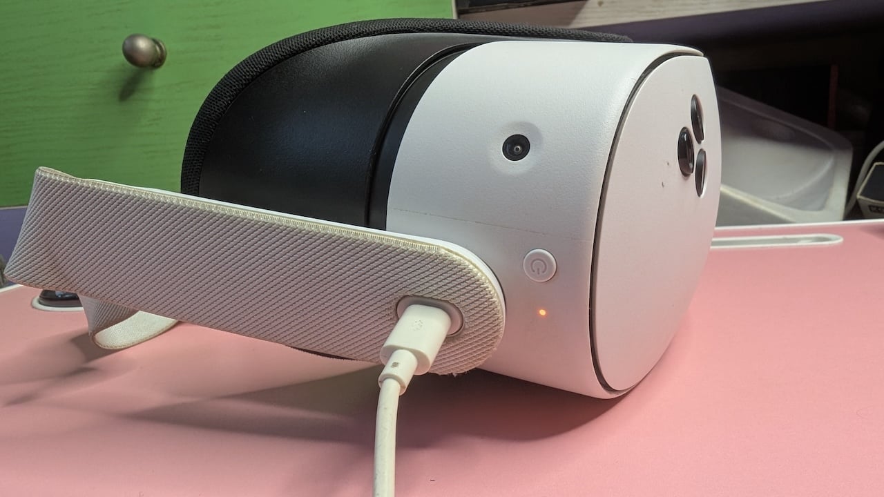 Side view of Meta Quest 3S headset plugged in with a USB-C charging cable