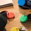 Colorful Chipolo Pop Bluetooth trackers on a desk beside keys