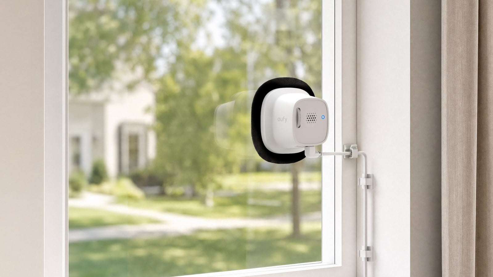Eufy Window Camera E10 mounted on the inside of a window overlooking a front yard